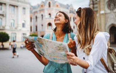 Fun, friends, travel and tourism concept. Beautiful happy women looking for direction in the city
